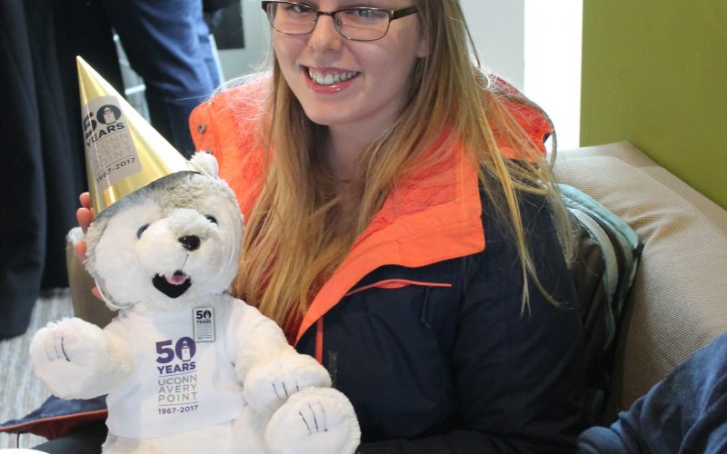 student holding stuffed husky