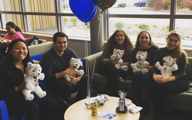 students holding stuffed huskies